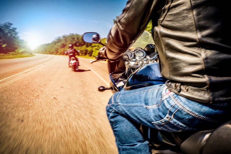 Bikers driving a motorcycle rides along the asphalt road (blurred motion). First-person view. Focus on the dashboard of a motorcycle